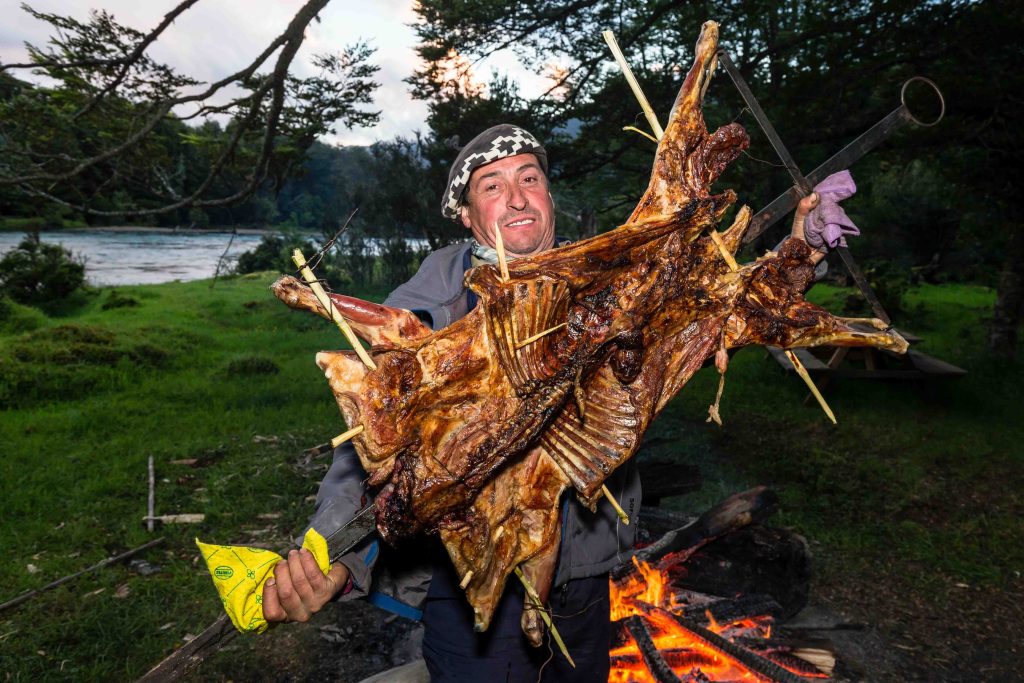 Patagonian lamb asado cooked over an open fire at the camp