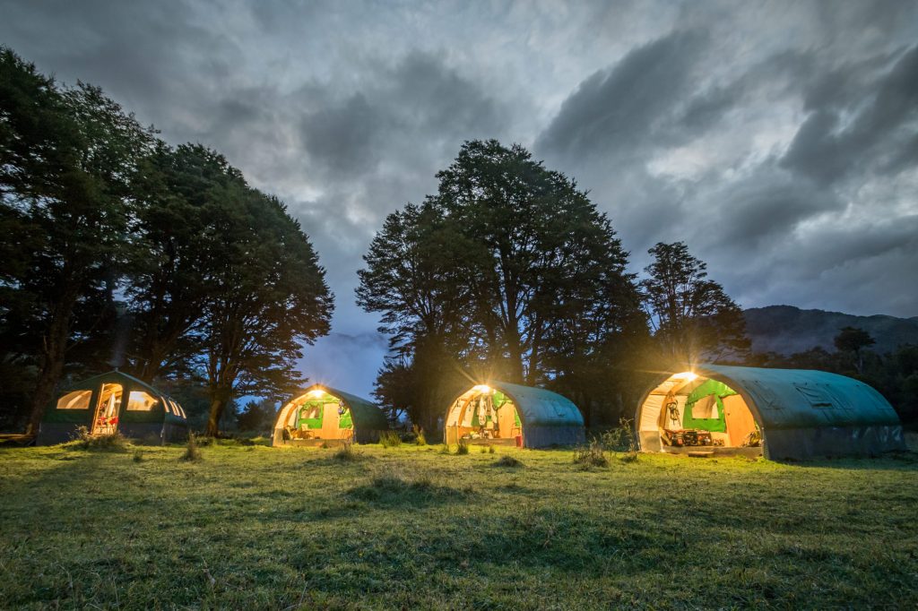 Illuminated tents at River of Dreams Base Camp at night