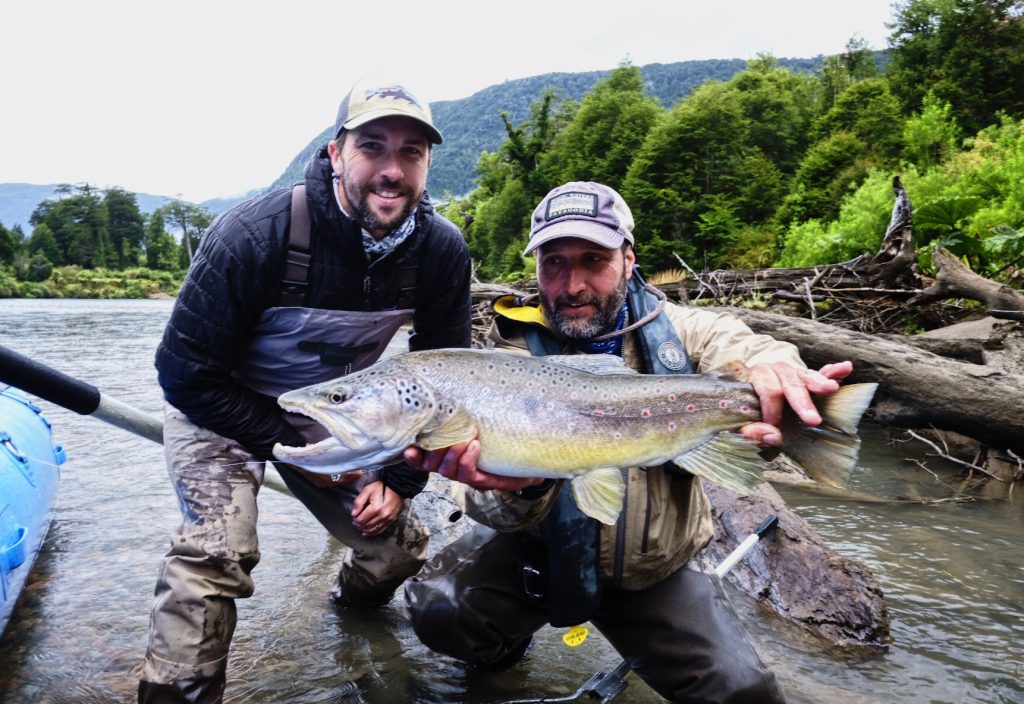 Guide José Martí and an angler with a brown trout in the river