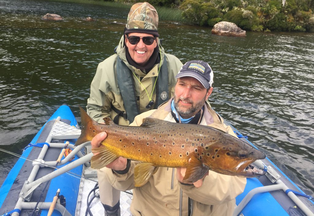 Guide José Martí and an angler in the blue drift boat with a golden brown trout